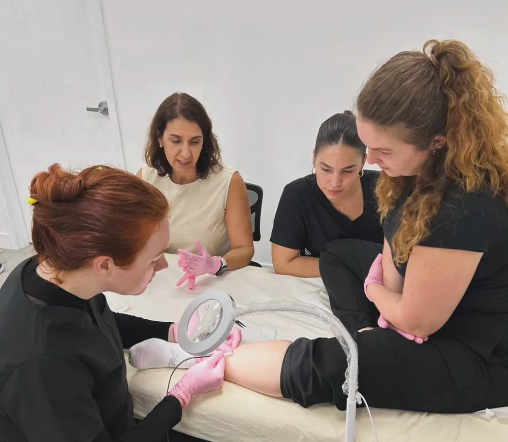 Students and instructor gathered around a treatment table