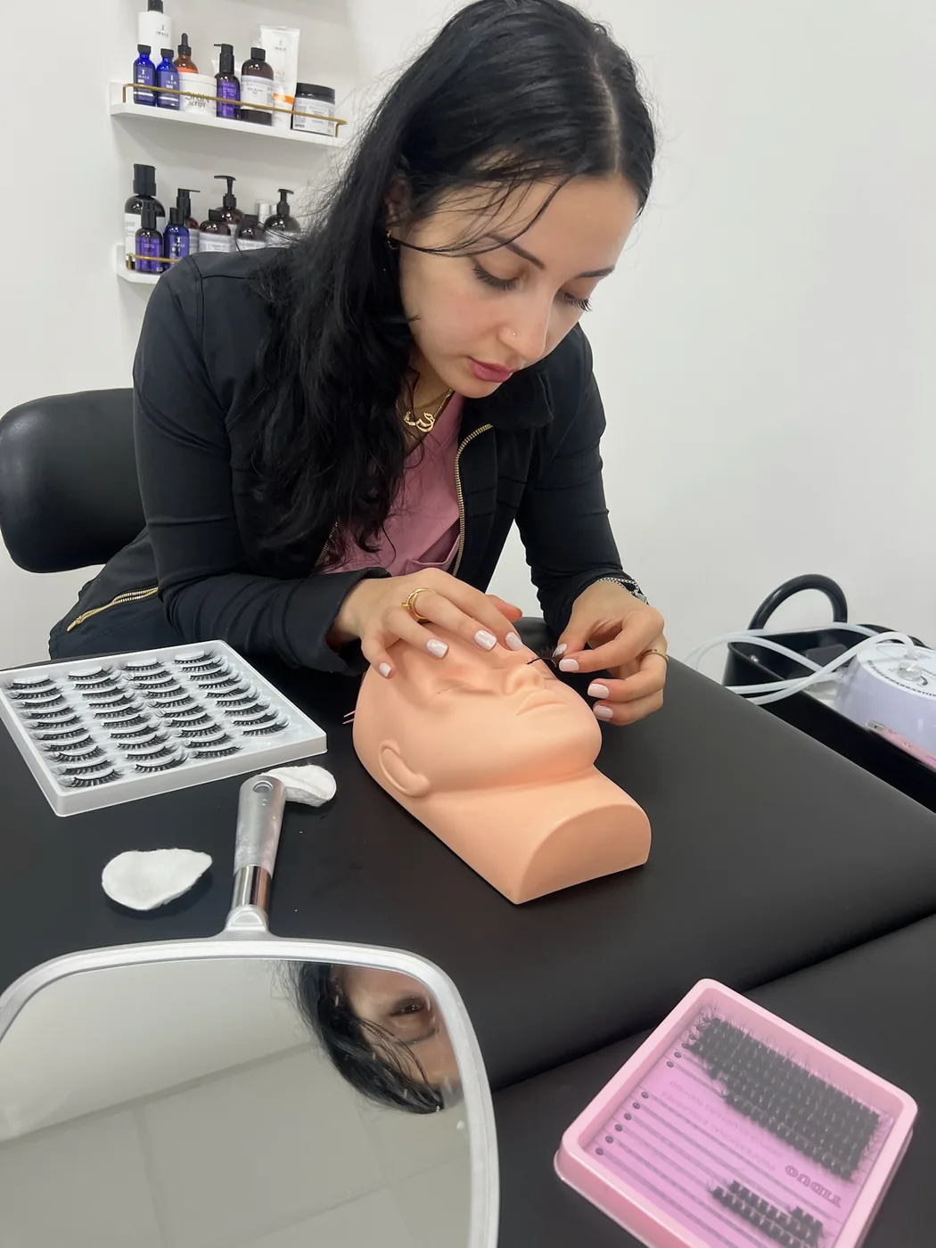Lash extension practice on a mannequin head with lash trays